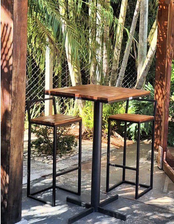 Mesa bistrô alta com duas banquetas, em área externa